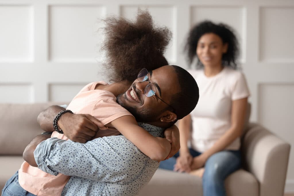 Dad happy hugging daughter during parenting time